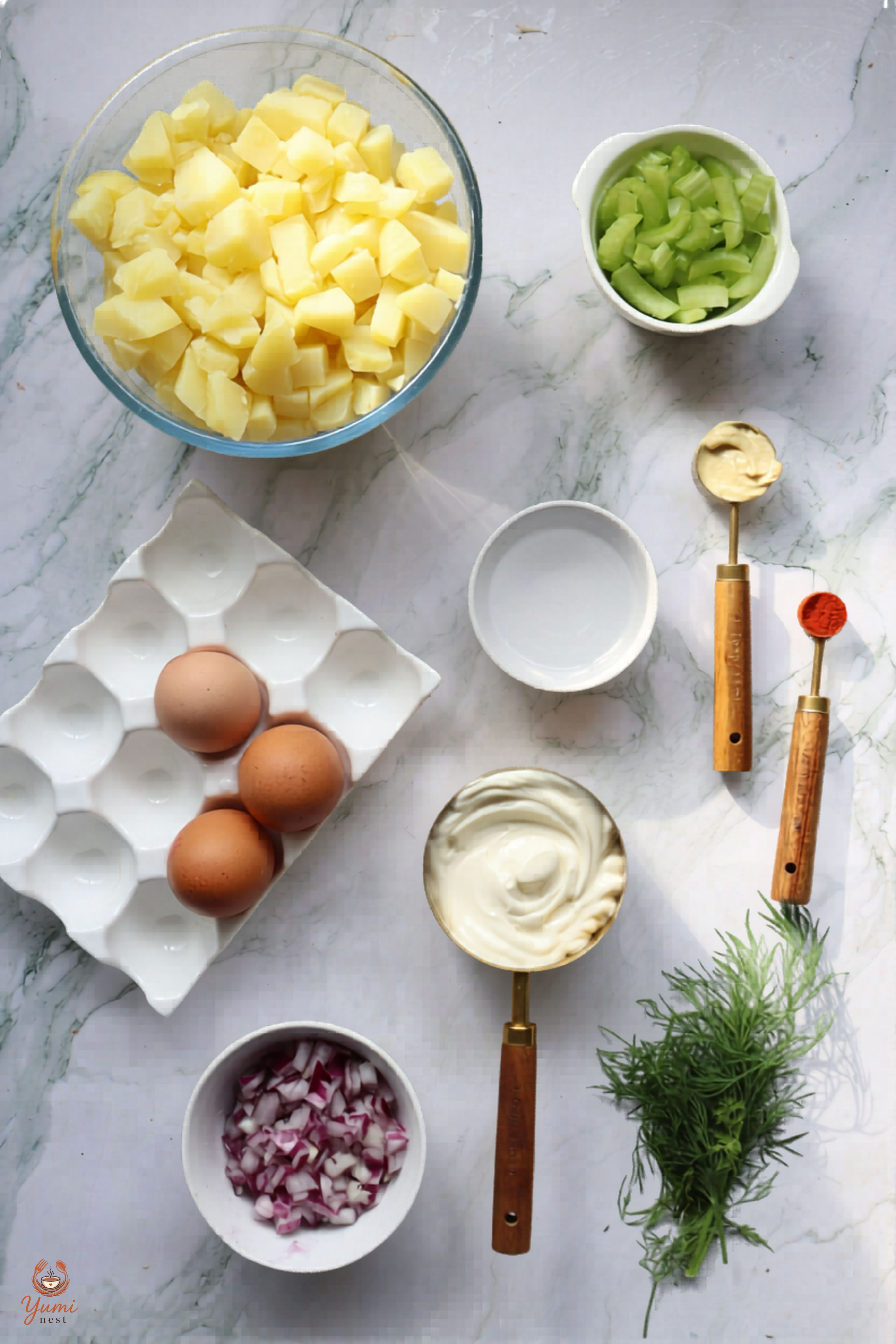 Labeled ingredients flat lay for classic potato salad with potatoes, celery, eggs, mayo, red onion, and dill