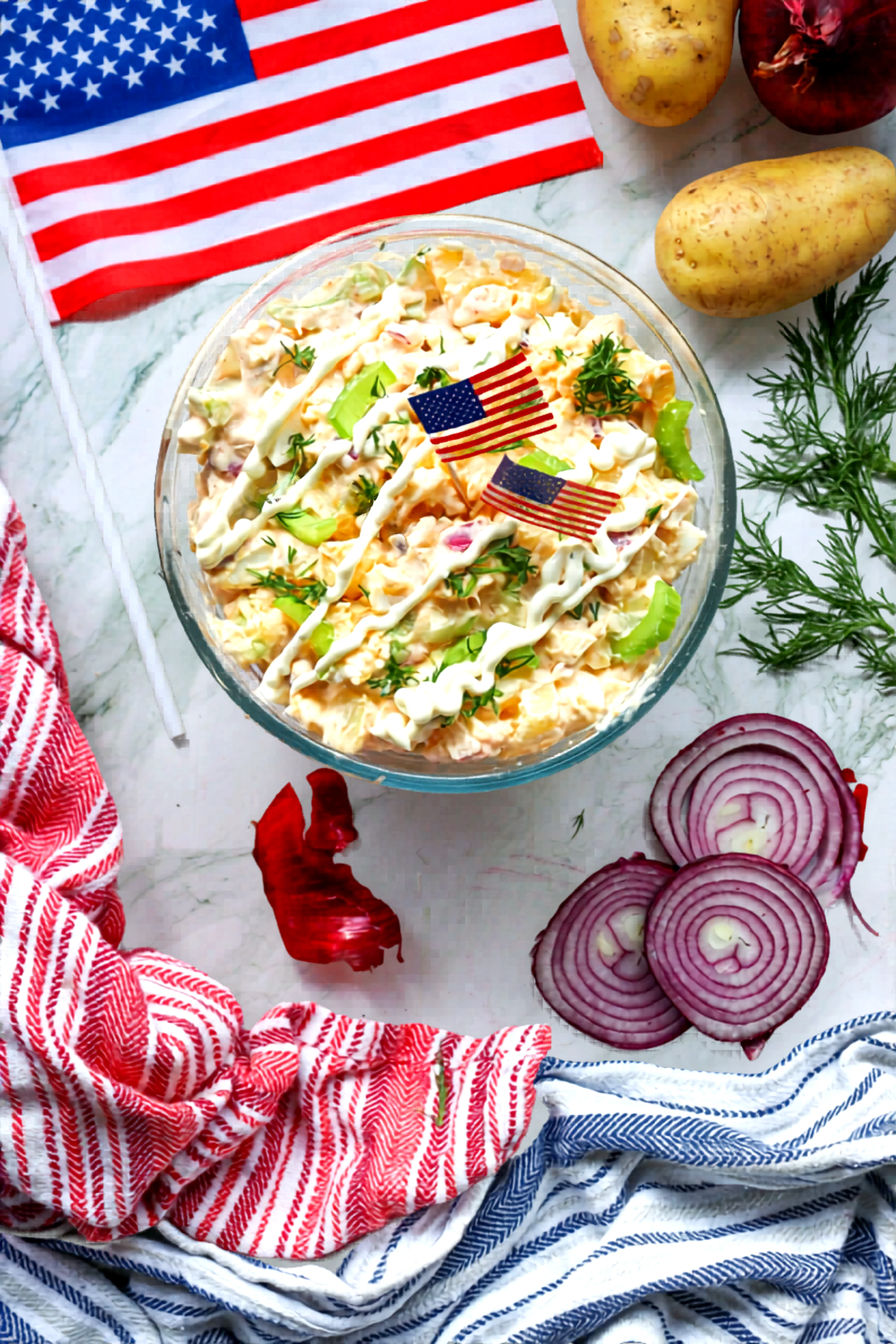 Finished patriotic potato salad topped with dill, celery, mayonnaise, and mini flags