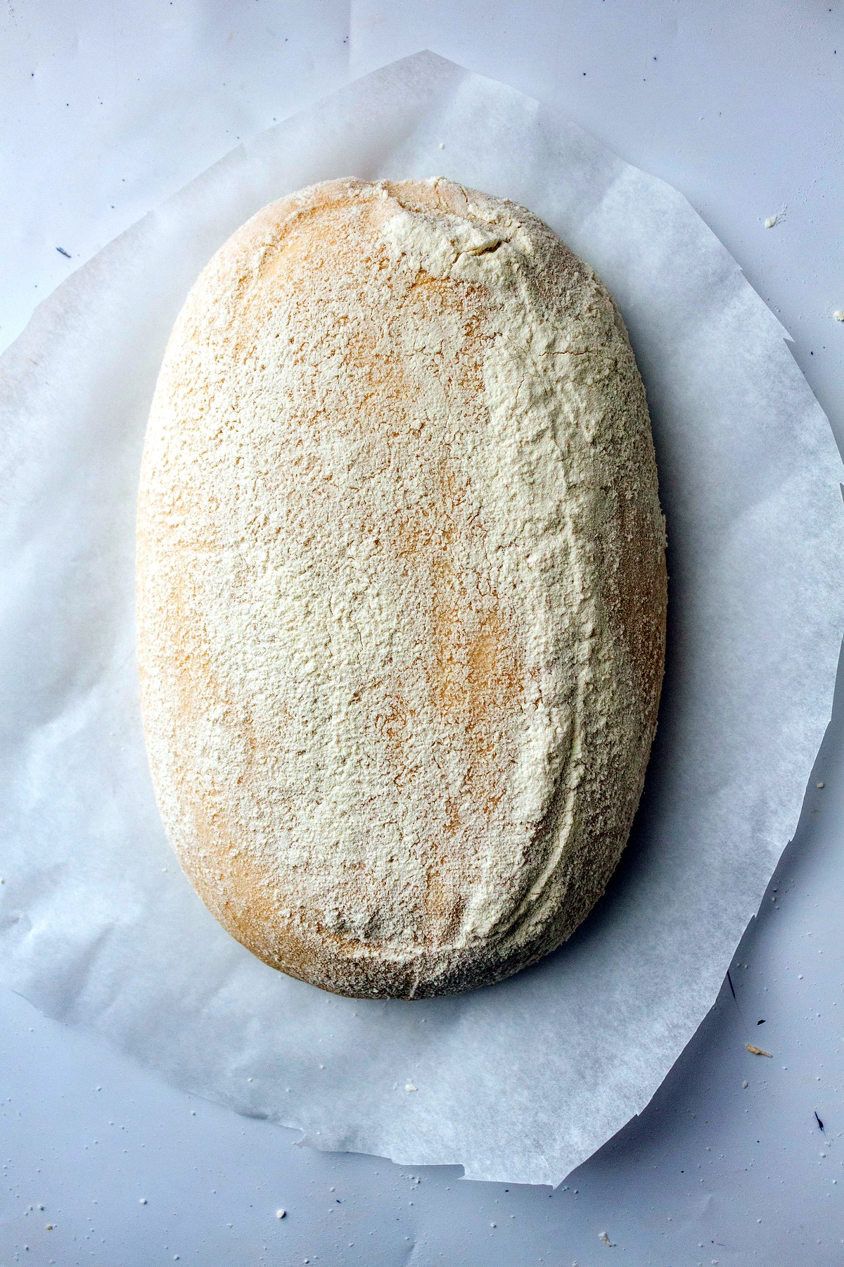 Shaped sourdough loaf turned onto parchment
