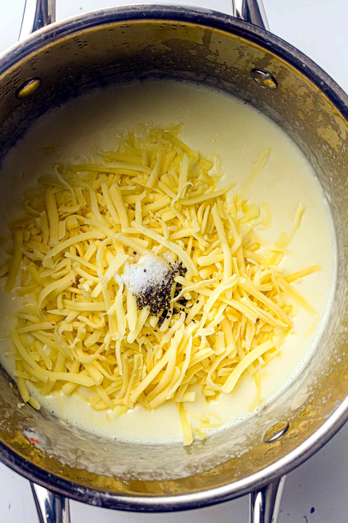 Shredded cheese added to white sauce for baked mac and cheese