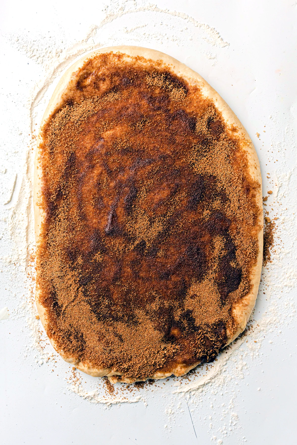 Cinnamon sugar filling spread over rolled dough