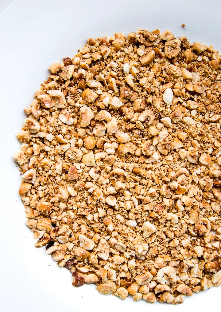 Crushing roasted hazelnuts into bits