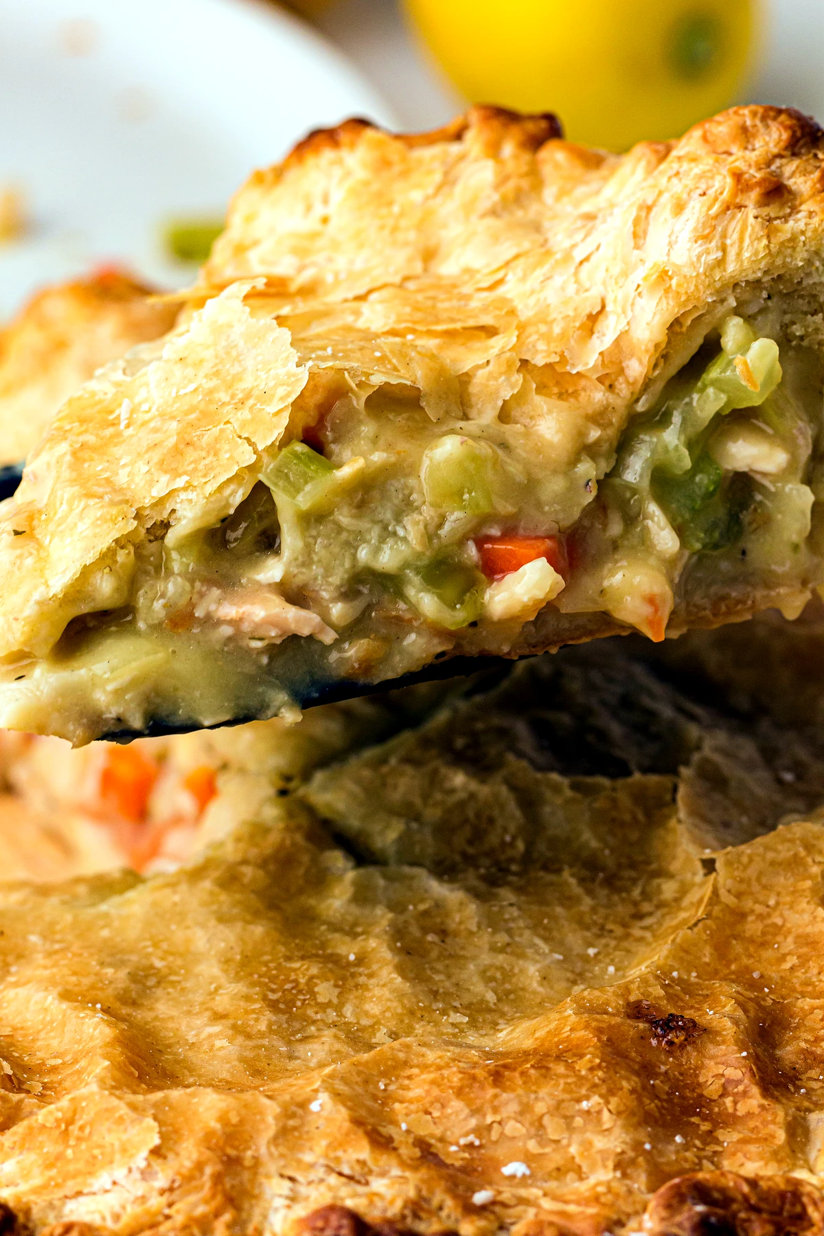 Slice of chicken pot pie being lifted from the dish