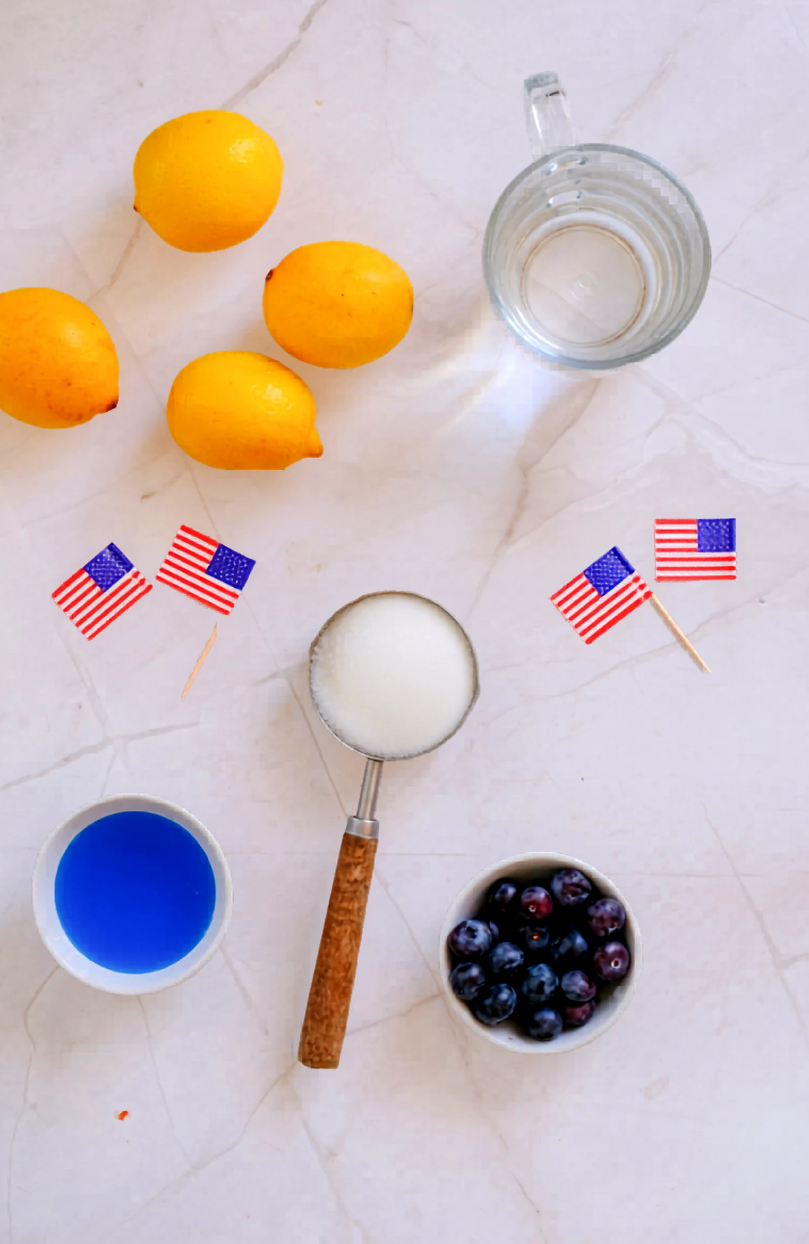 Ingredients for a Fourth of July blue curacao mocktail laid out on a light counter.