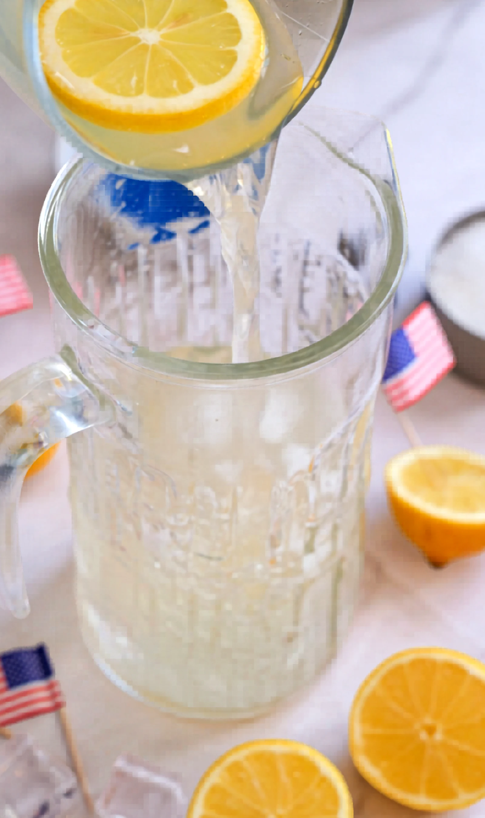 Lemon mixture being poured into a pitcher with ice.