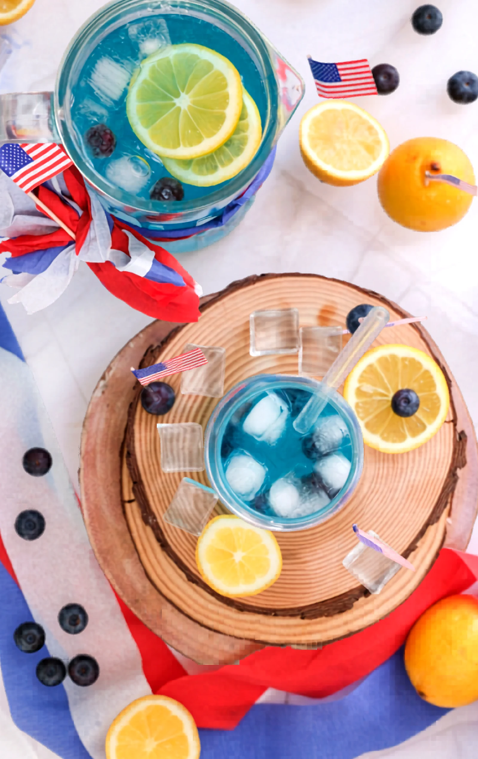 Finished blue curacao mocktail in a pitcher with lemon slices and blueberries.