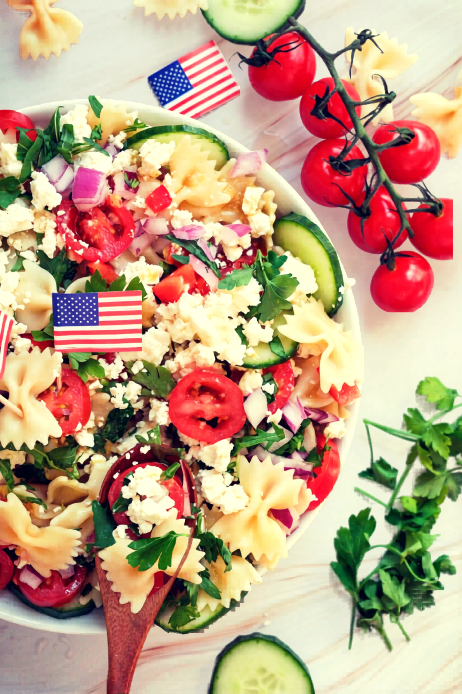 Close angle of Fourth of July pasta salad with tomatoes and cucumber.