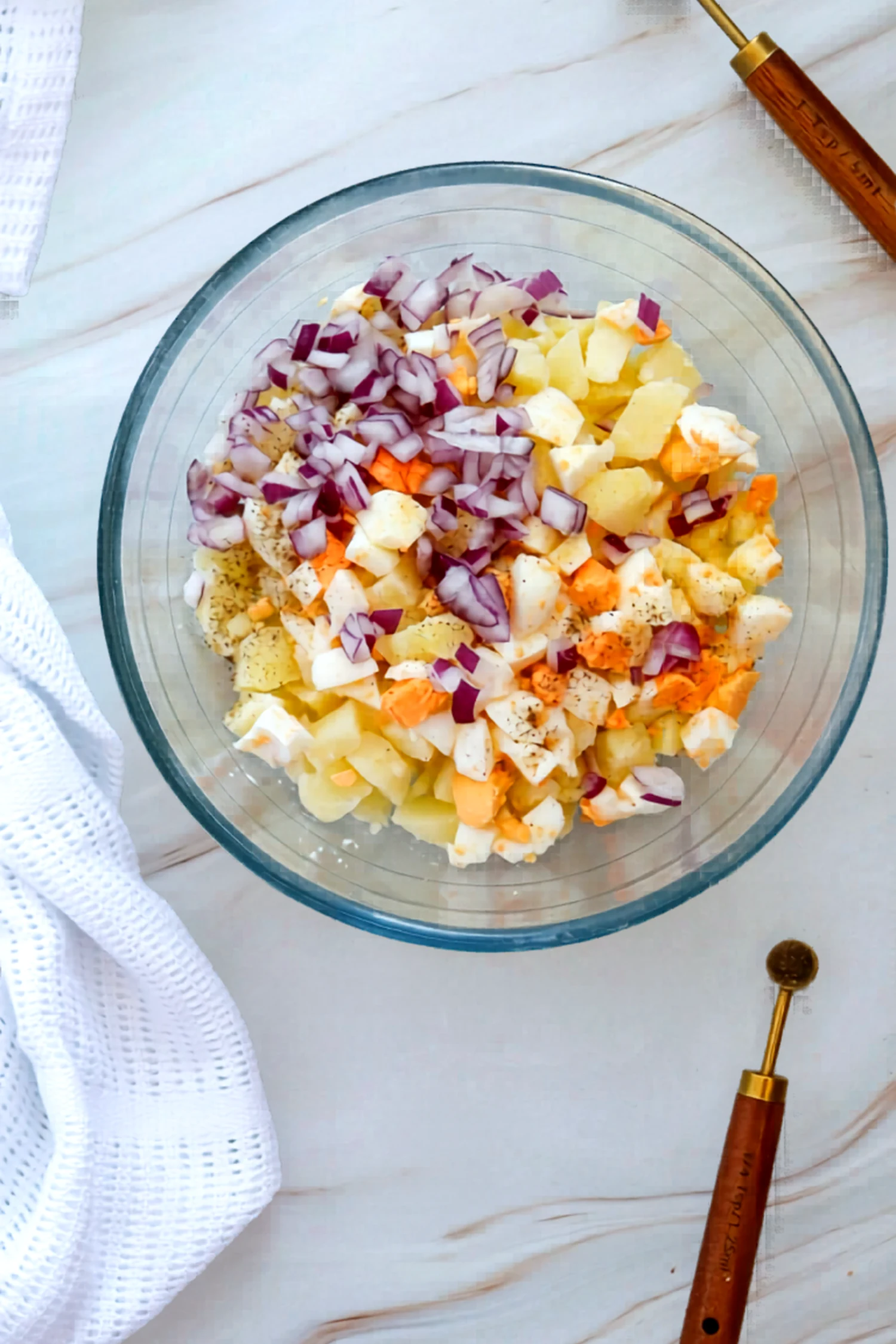 Red onion added to the bowl of potatoes and eggs