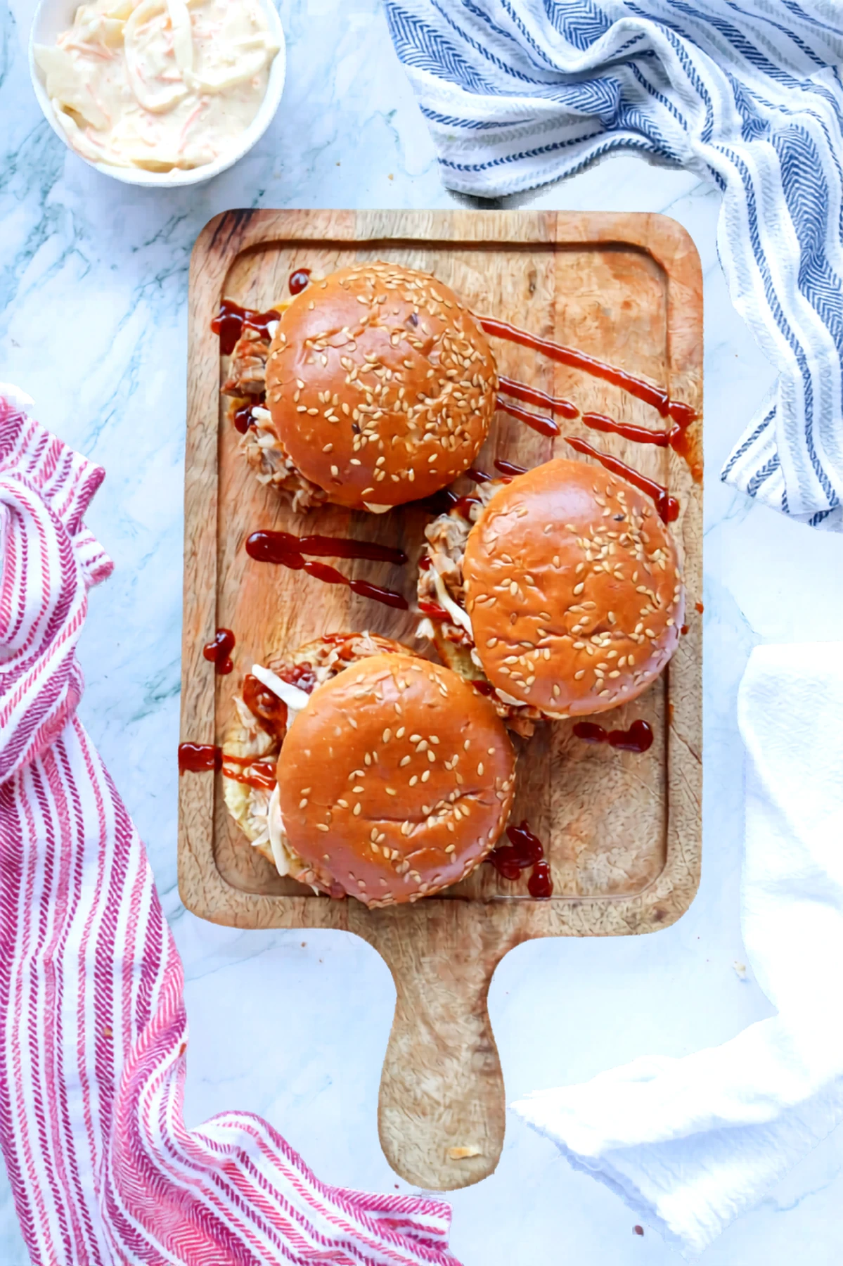 Finished pulled pork barbecue sandwiches on a wooden board.