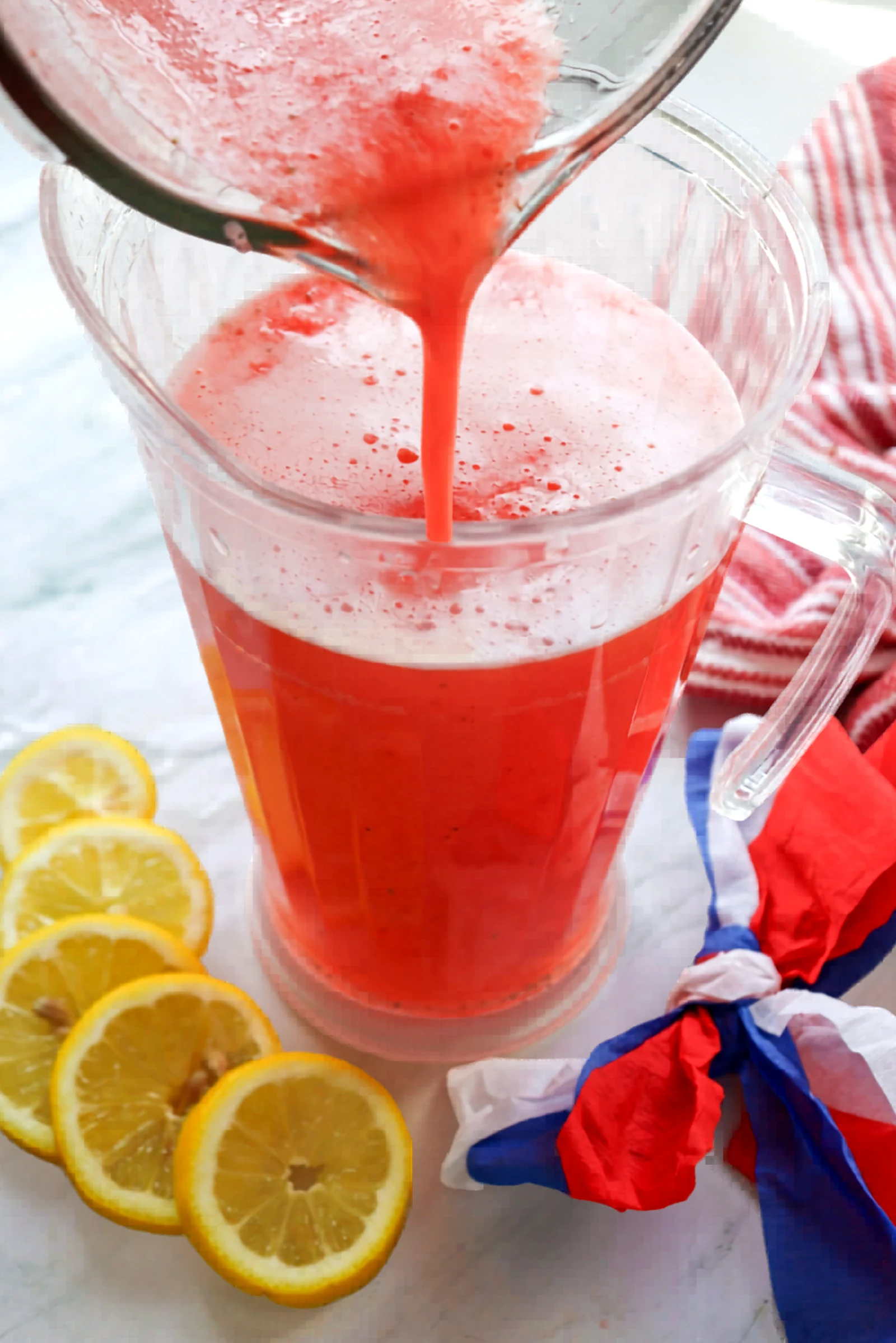 Blended strawberry lemonade poured into a pitcher