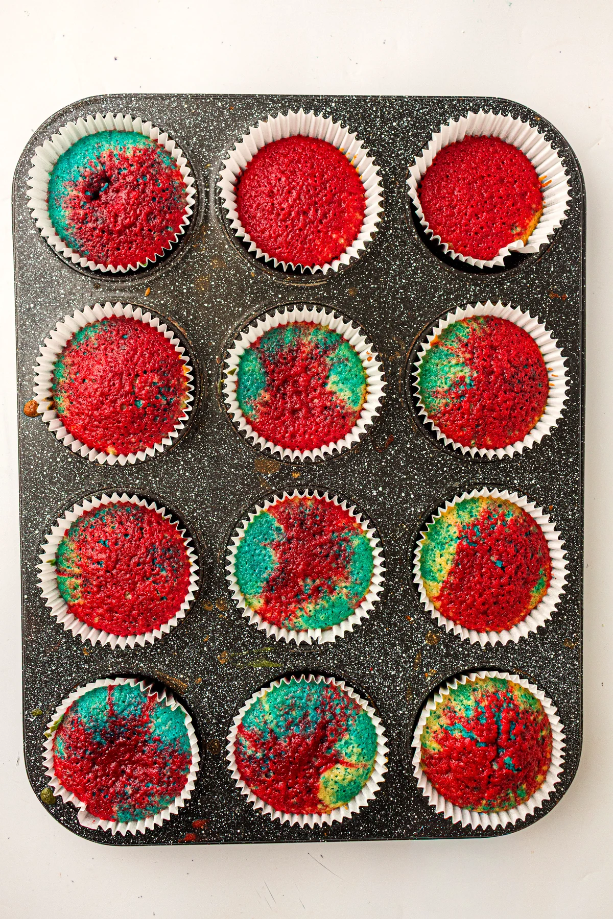 Baked tie-dye cupcakes in a muffin pan