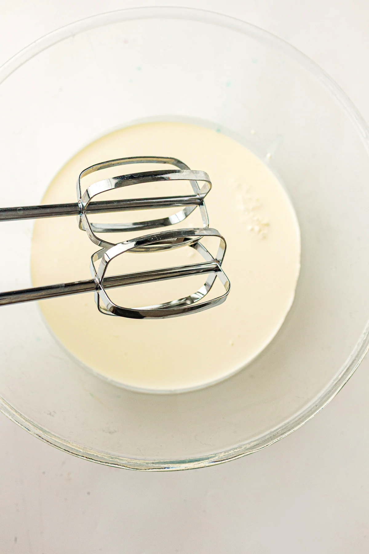 Buttercream being mixed in a glass bowl