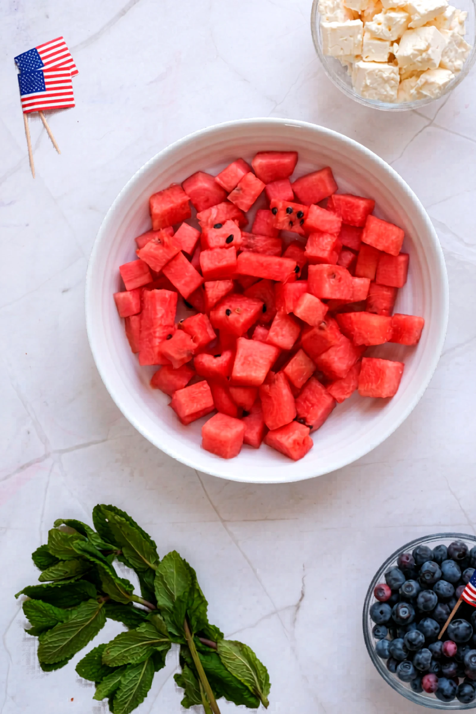 Watermelon cubes added to a bowl