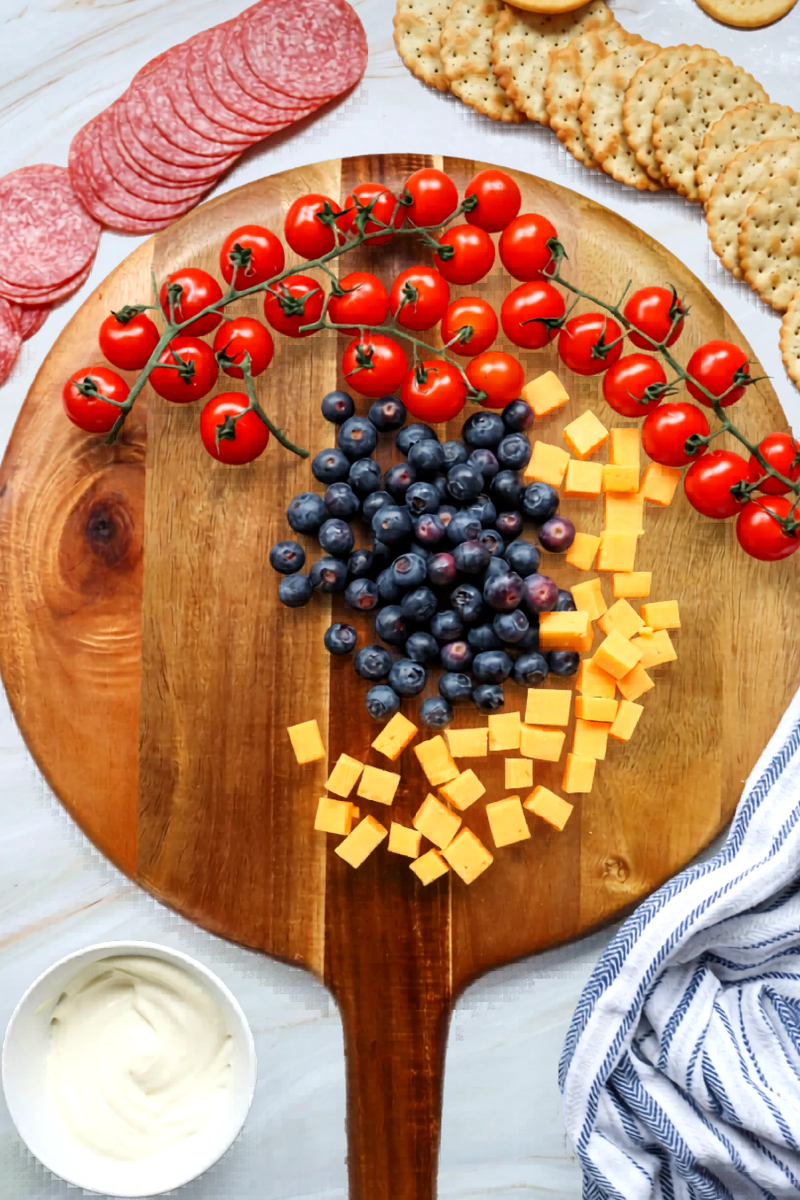 Blueberries, cheddar, and tomatoes arranged on the board