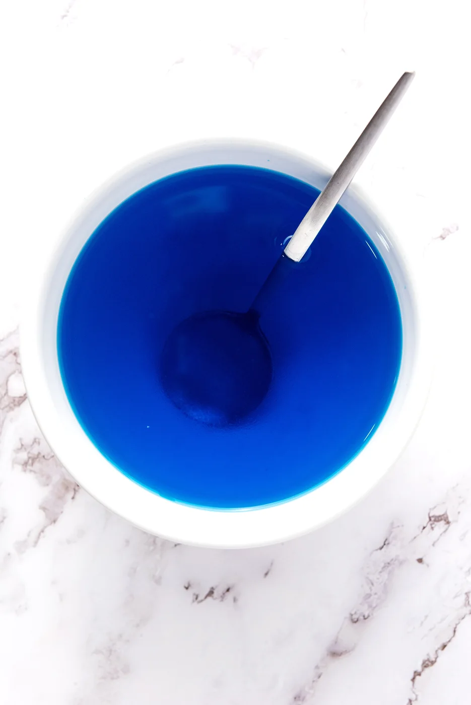 Blue gelatin stirred with water for patriotic Jell-O shots