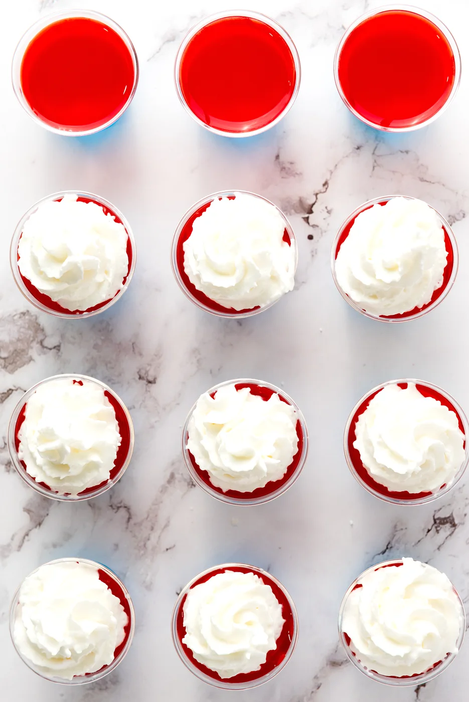 Whipped cream added to layered patriotic Jell-O shots