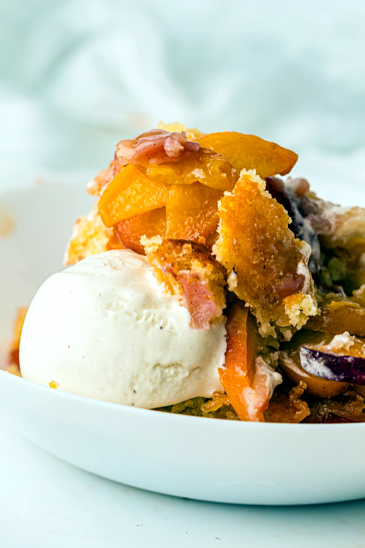 Close bowl of peach cobbler with ice cream