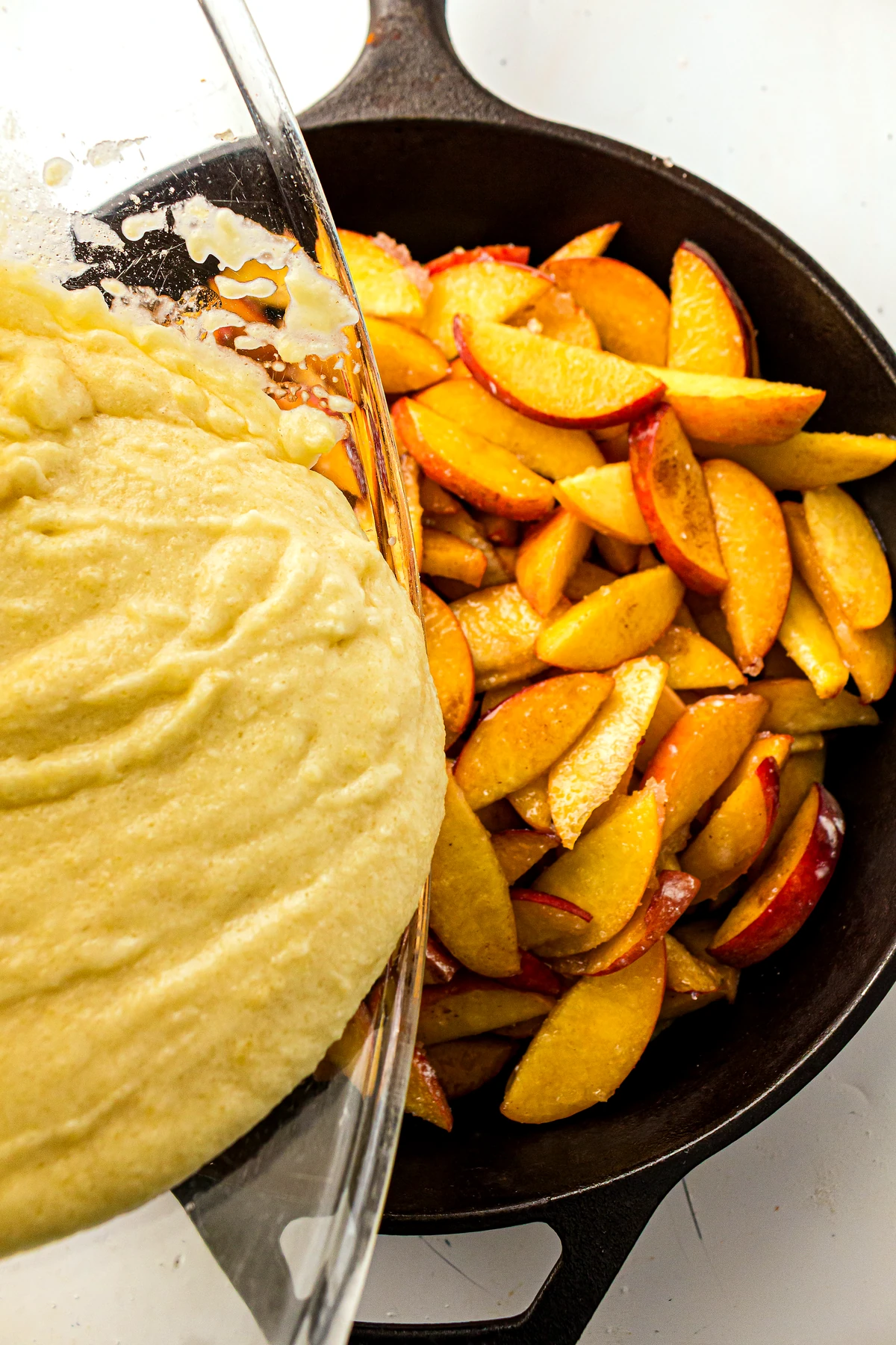 Cobbler batter poured over peaches