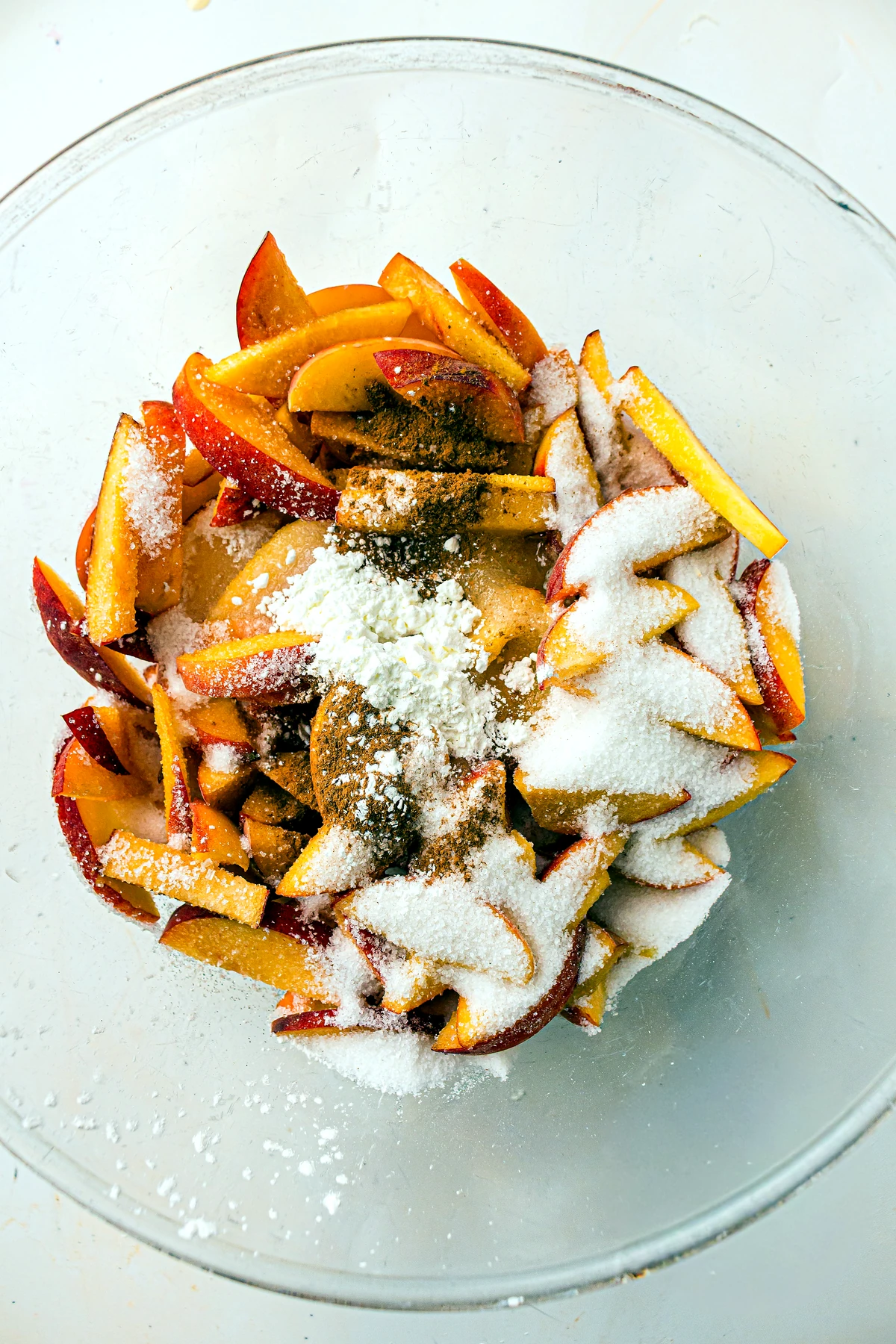 Peaches tossed with sugar and cinnamon for cobbler