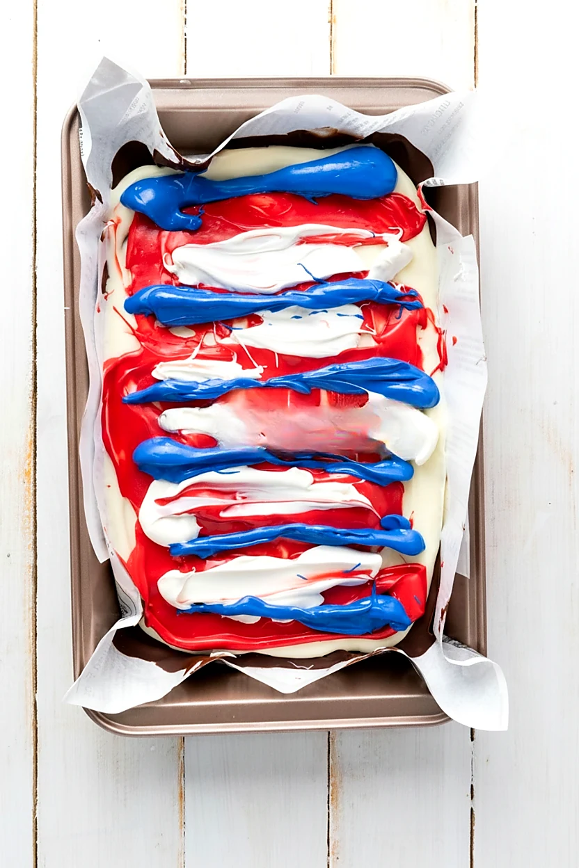 Blue candy melt stripes added over red and white chocolate bark