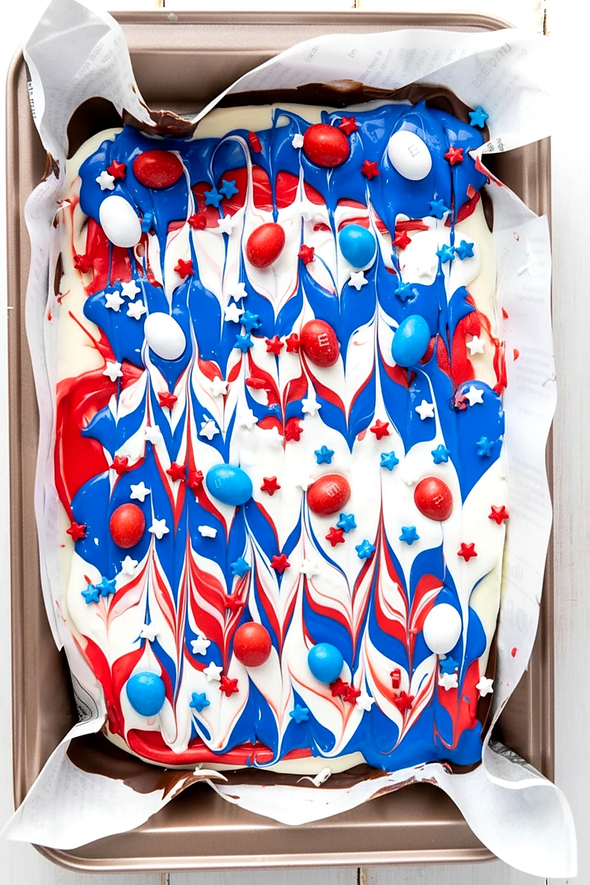 Patriotic candies and star sprinkles added to red white and blue chocolate bark