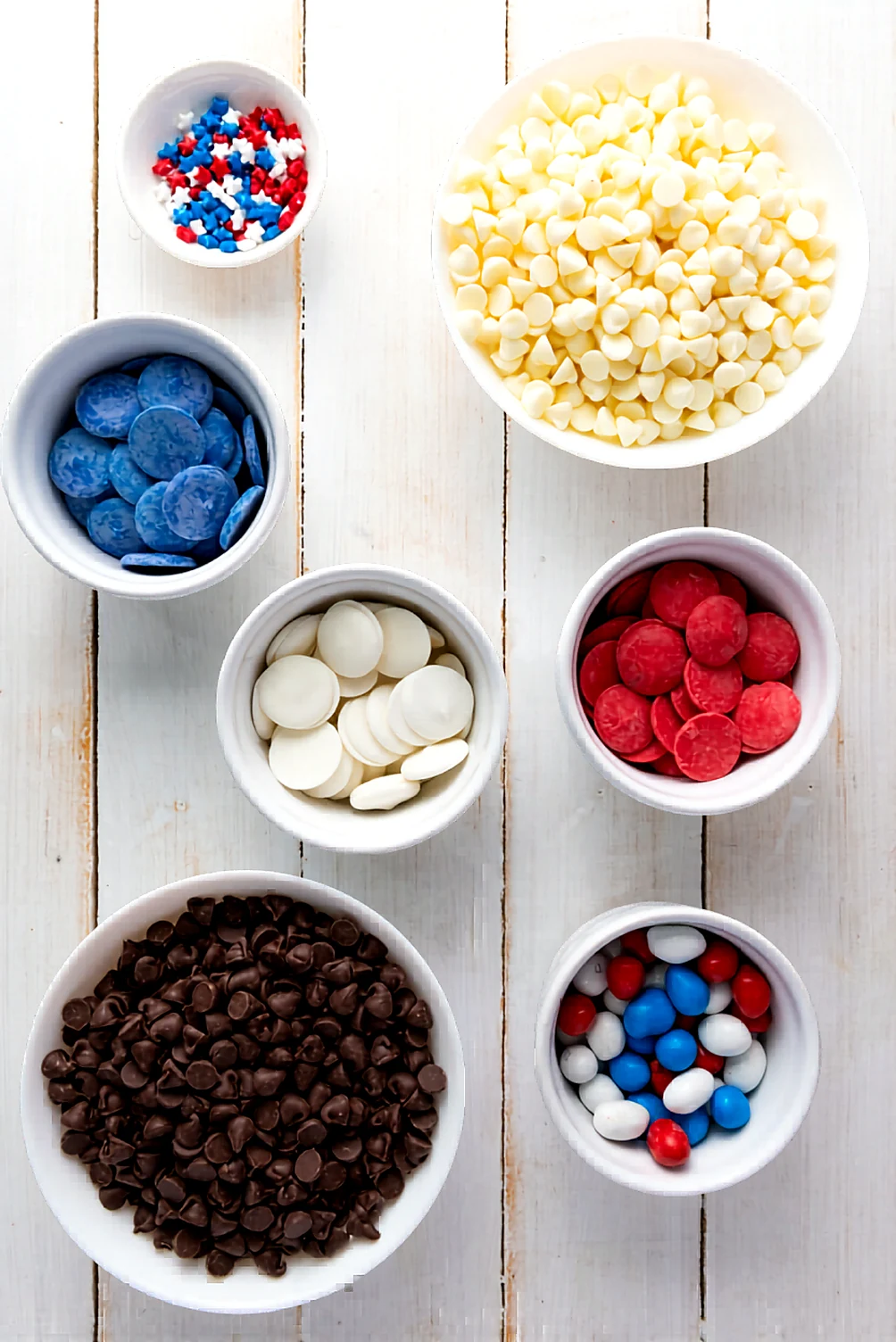 Ingredients for red white and blue chocolate bark with chocolate chips candy melts M and M candies and sprinkles