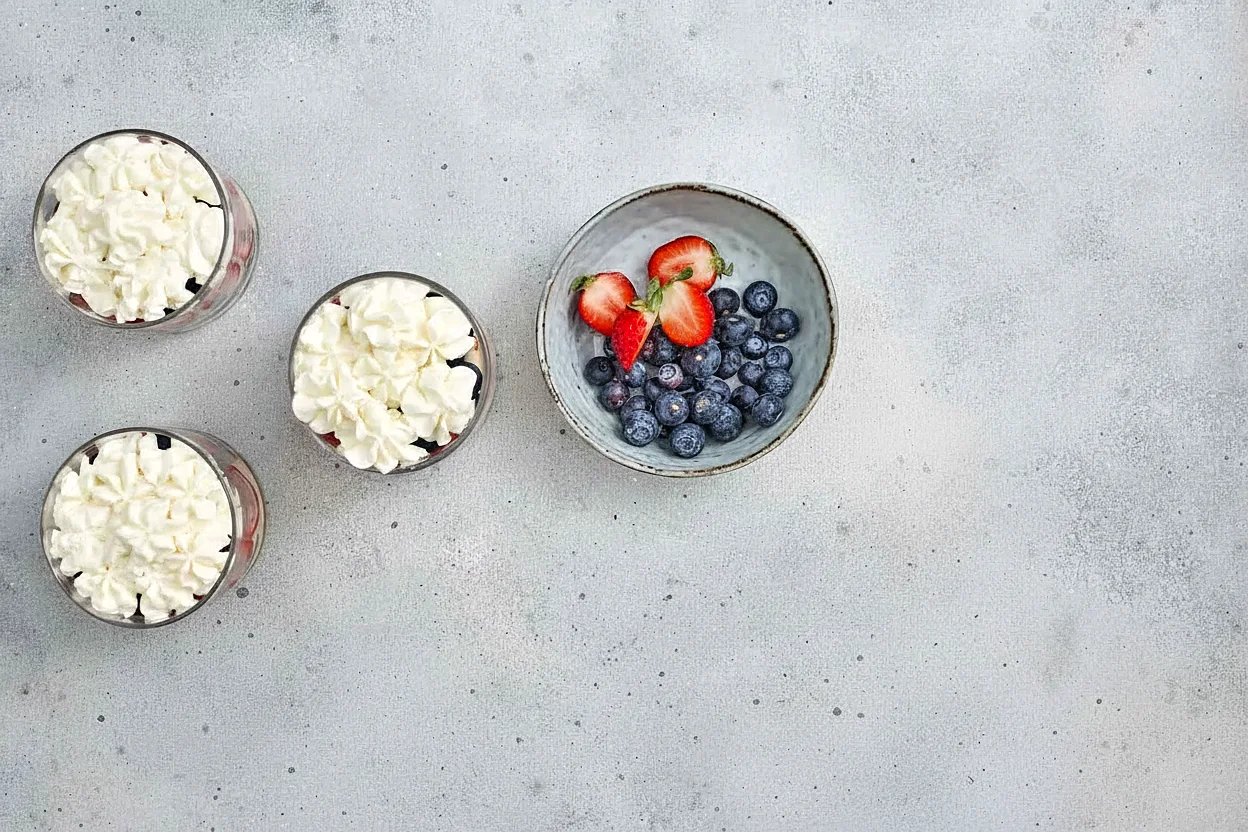 Whipped cream and berries ready for trifle cups