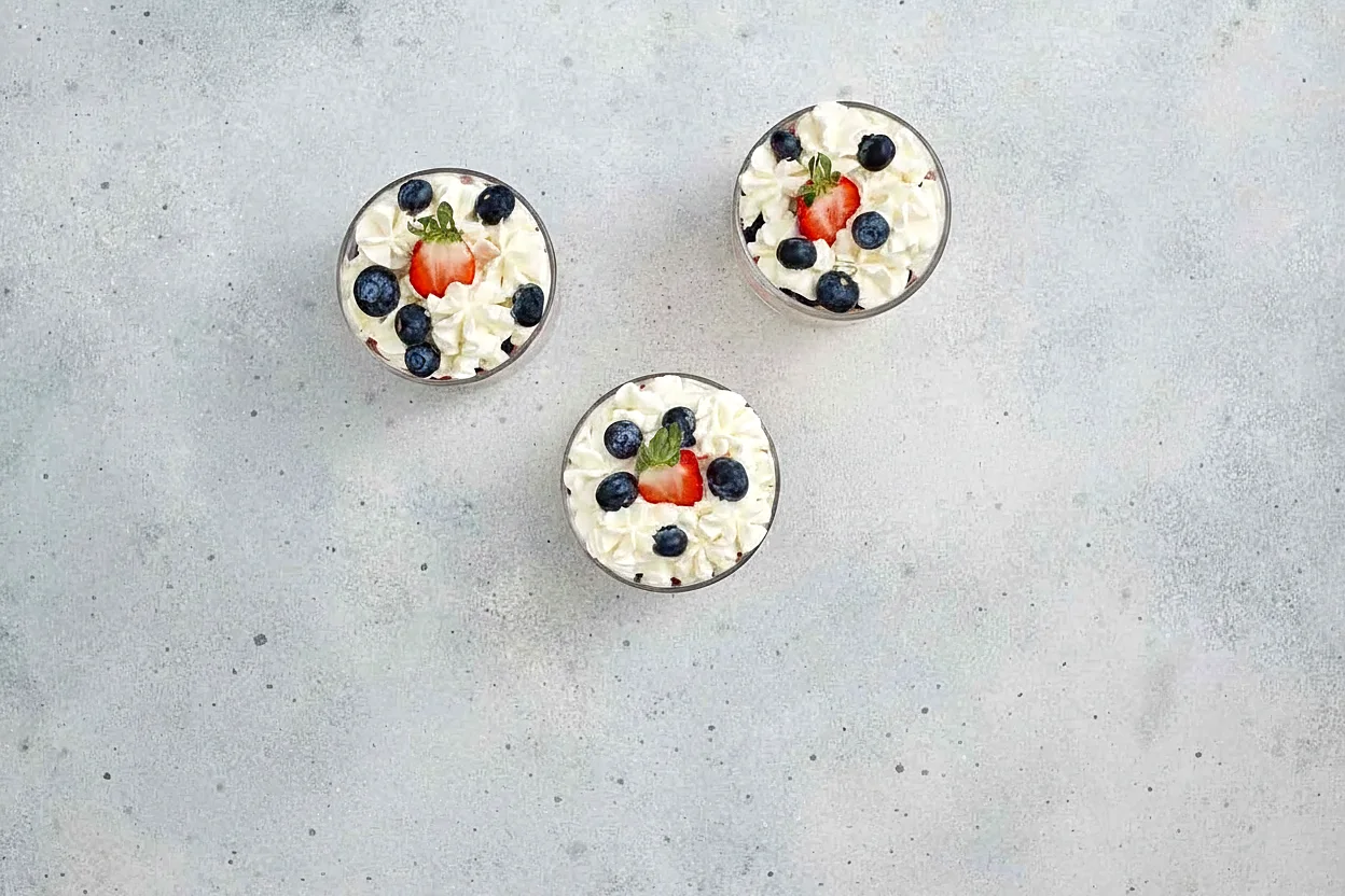 Finished red white and blue trifle cups topped with whipped cream and berries