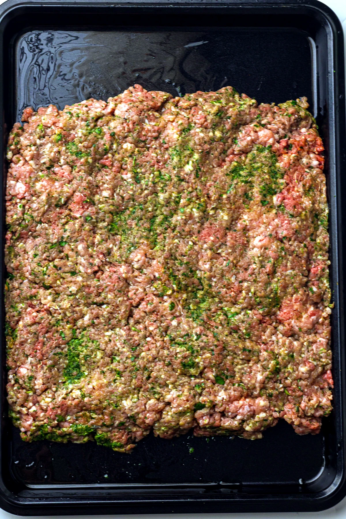 Kofta mixture pressed onto a sheet pan
