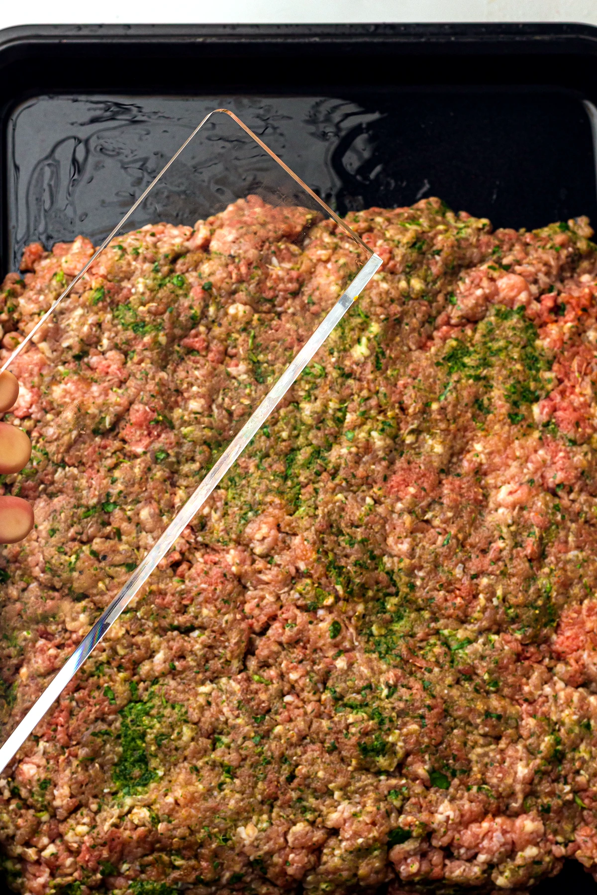 Sheet pan kofta mixture scored into long portions