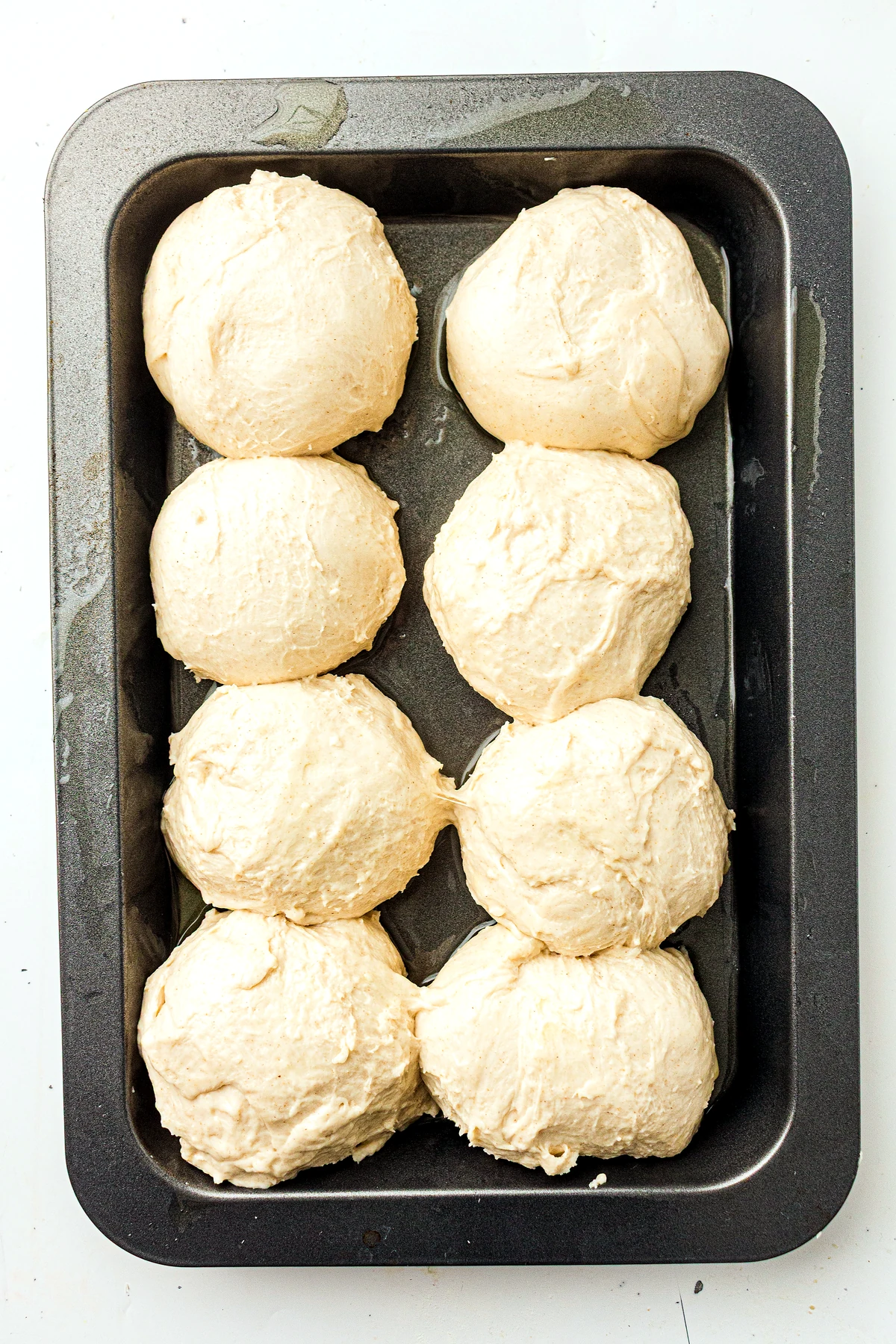 Six shaped sourdough dinner rolls in a pan