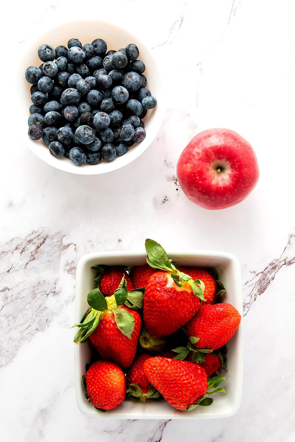 Ingredients for star spangled fruit salad with strawberries blueberries and apple