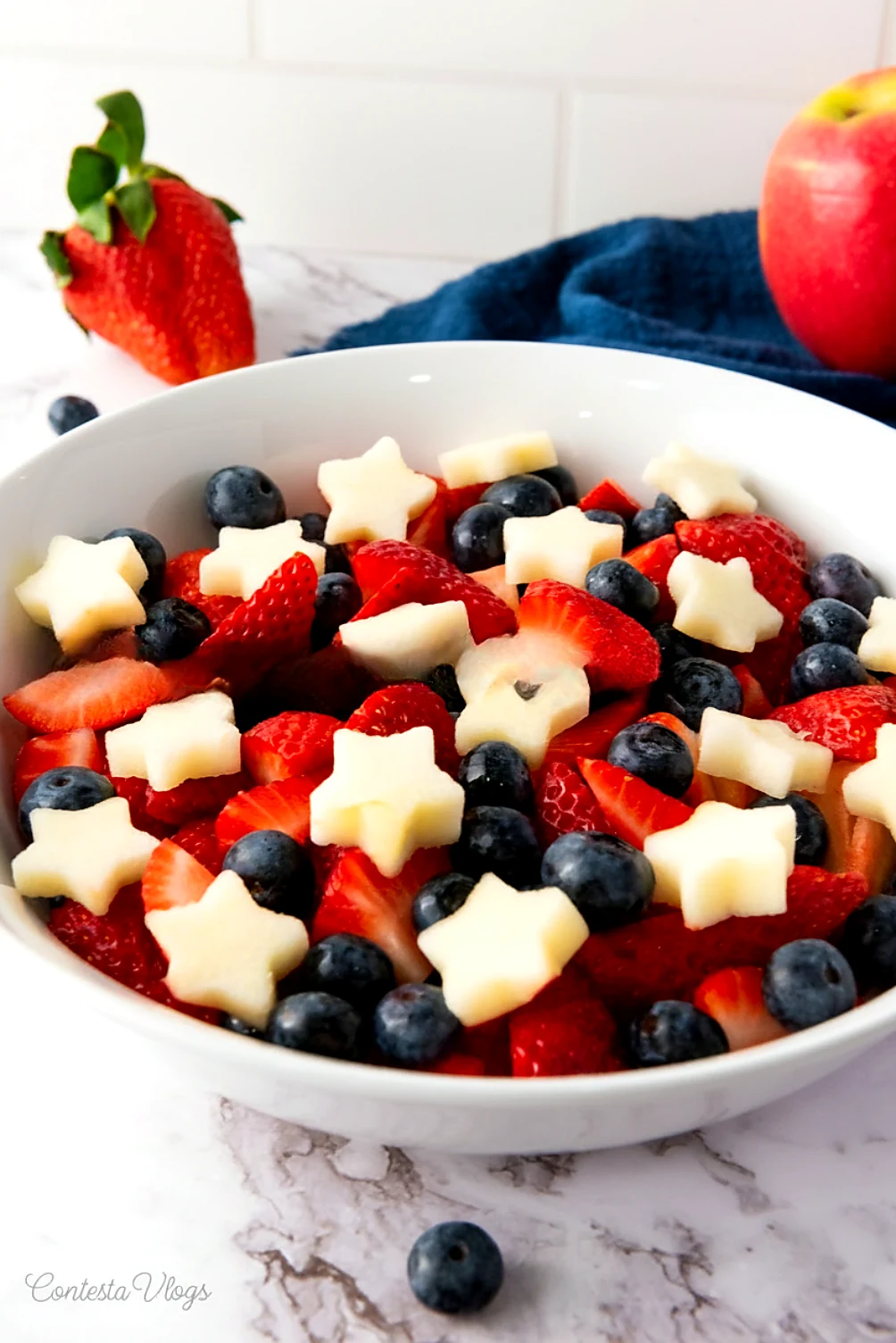 Serving bowl angle of star spangled fruit salad with apple stars and berries