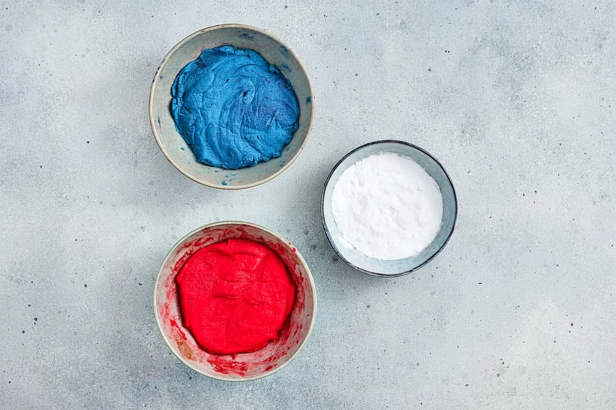 Two bowls of red and blue colored crinkle cookie dough