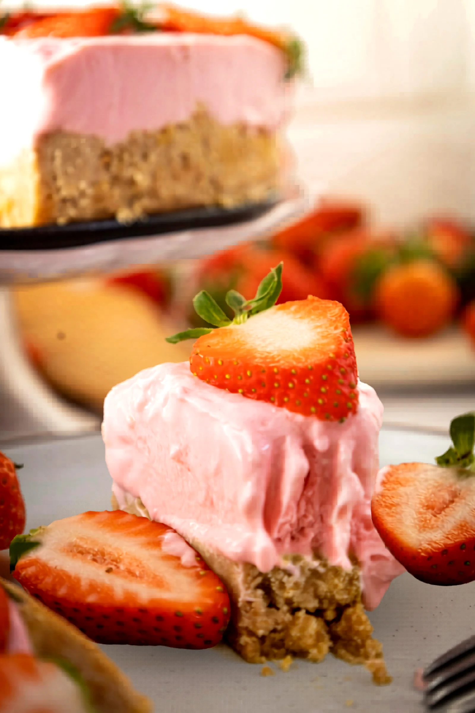Close up bite of strawberry no bake cheesecake with strawberries around it.