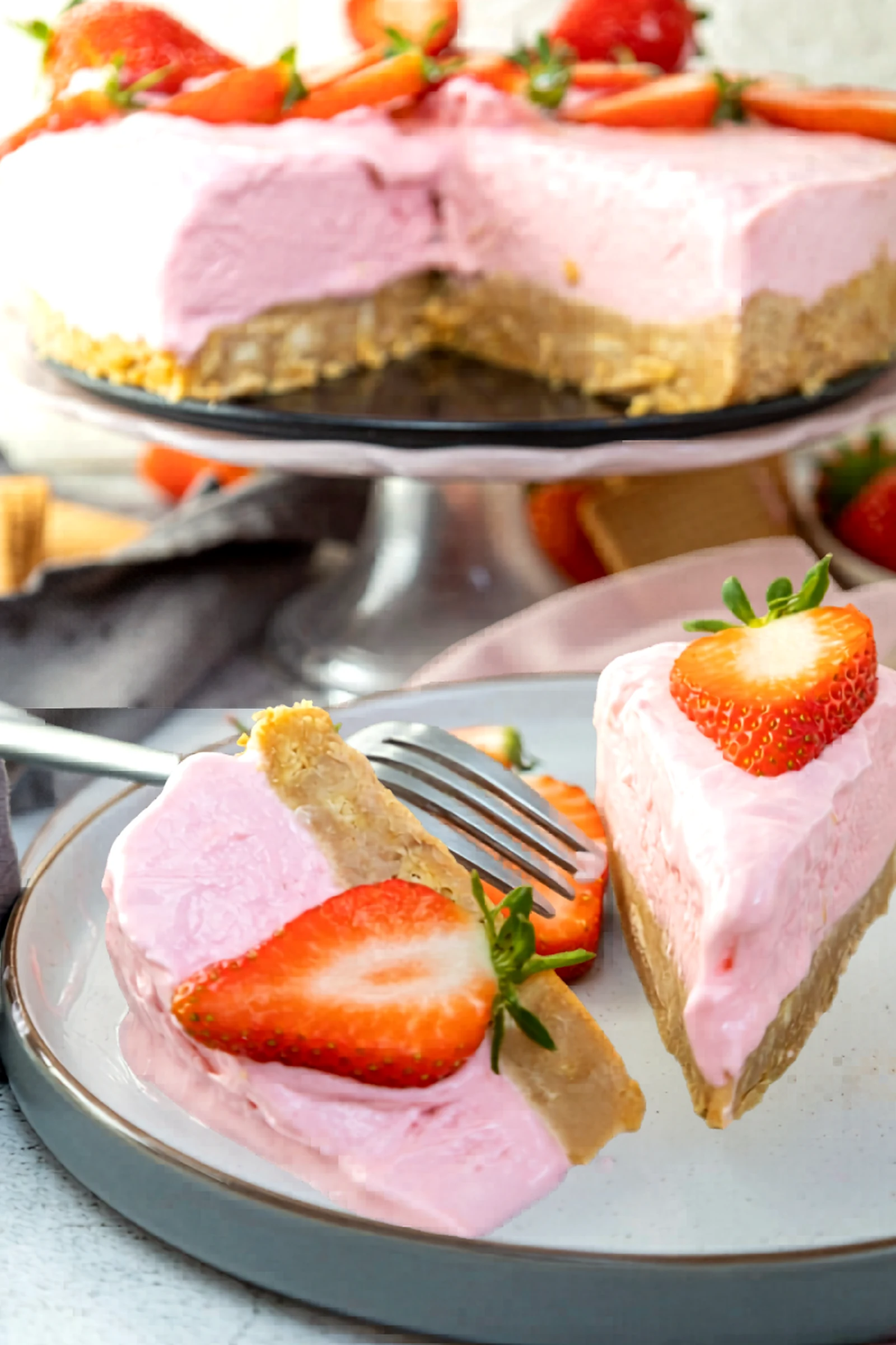 Plated slice of strawberry cheesecake with the whole cake in the background.