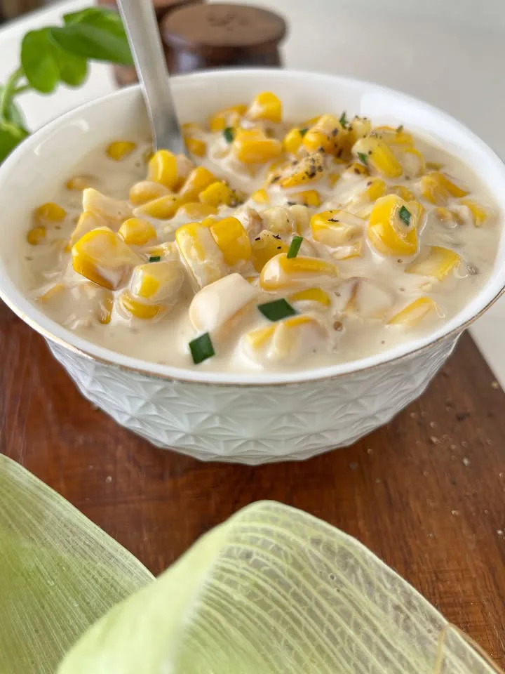 Creamed corn served in a white bowl with chives