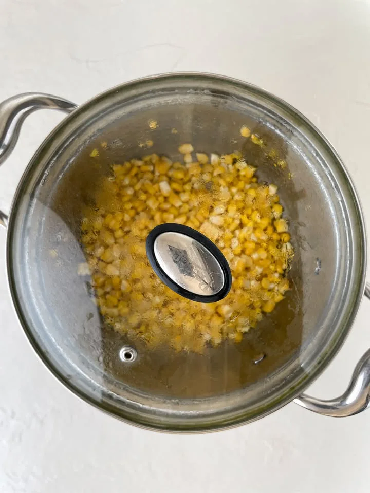 Fresh corn simmering in a covered pan