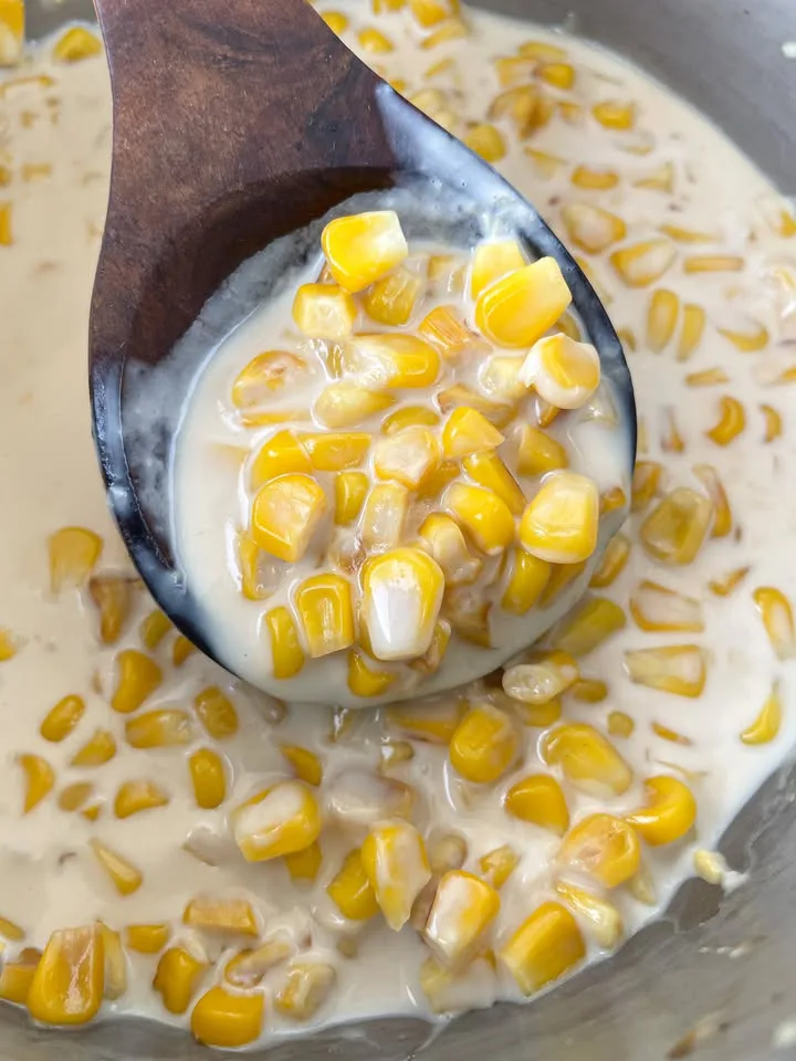 Spoonful of easy creamed corn with visible sweet corn kernels