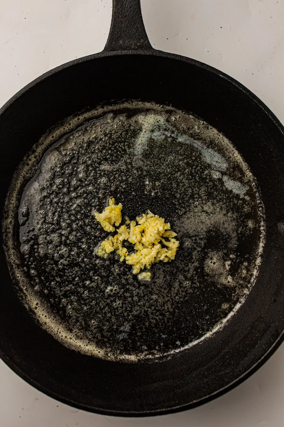 Minced garlic cooking gently in melted butter
