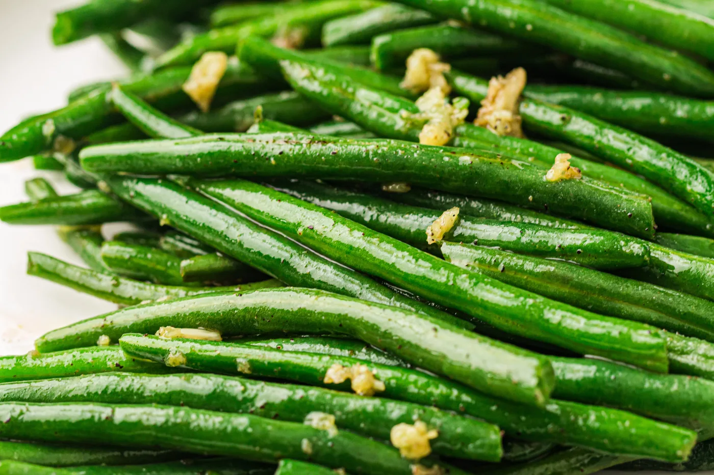 Garlic butter green beans arranged on a white serving platter