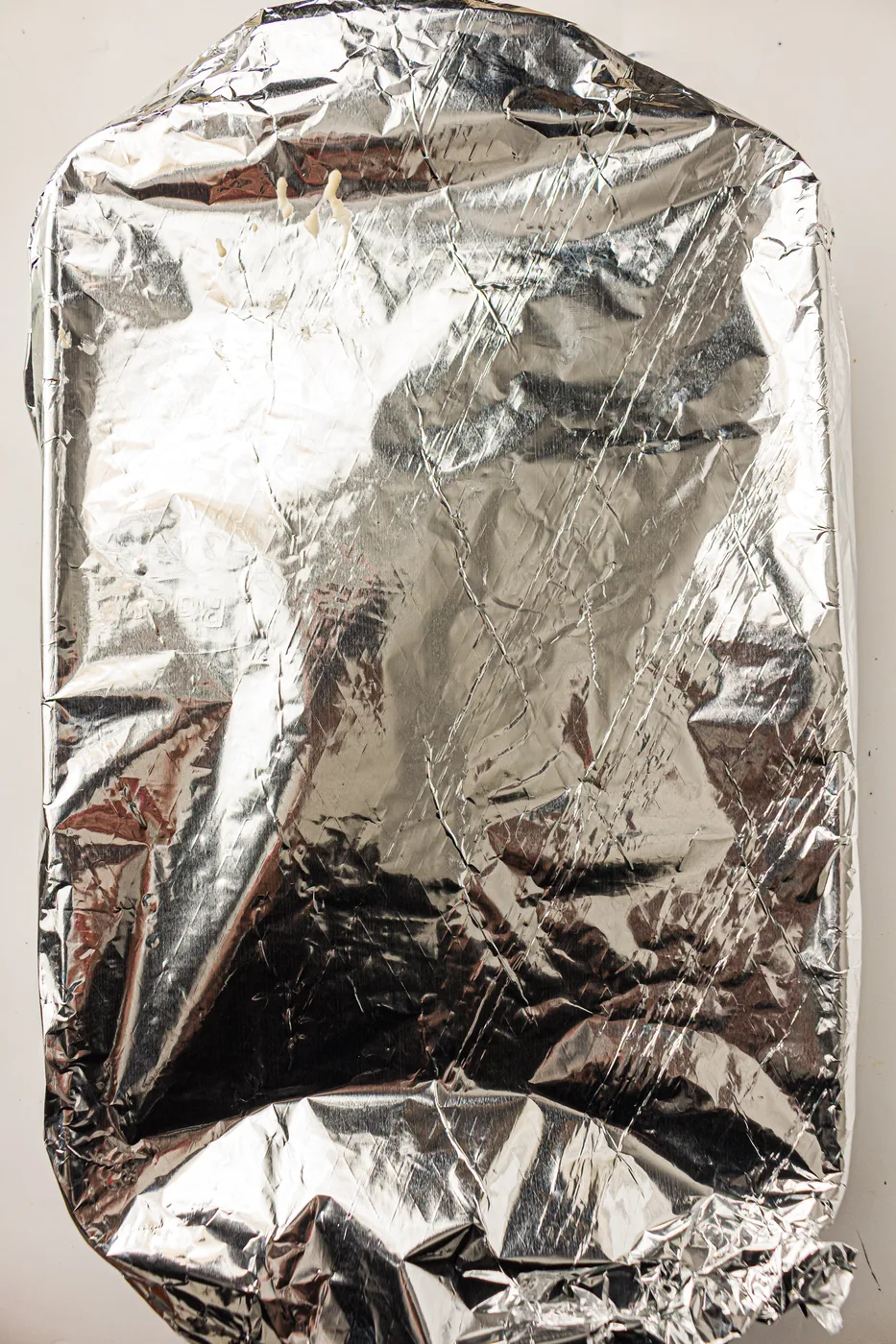 Scalloped potatoes covered tightly with foil before baking