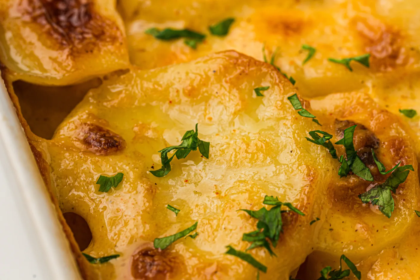 Serving of tender scalloped potatoes lifted from the casserole
