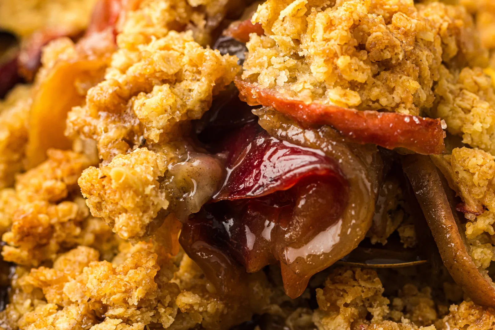 Spoonful of warm apple crisp with tender cinnamon apples and oat topping